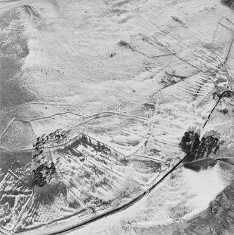 Oblique aerial view centred on the remains of the field-system and rig with fort adjacent, taken from the SE.