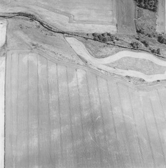 Oblique aerial view centred on the cropmarks of the enclosures, taken from the WSW.
