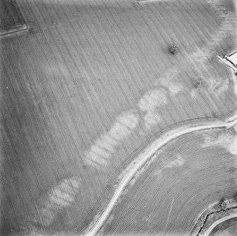 Leadketty, oblique aerial view, taken from the SSW, centred on the cropmarks of a possible enclosure, pits and rig. The cropmarks of a possible henge, ring-ditches and pits are visible in the top right-hand corner of the photograph.