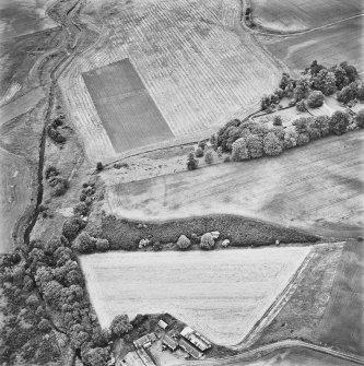 Inverdunning House and Wellhill, oblique aerial view, taken from the SW, centred on the cropmarks of an enclosure, pit-circles, cropmarks and pits. Inverdunning House and walled garden are visible in the top right-hand corner of the photograph and Wellhill farmsteading is shown in the bottom left-hand corner.
