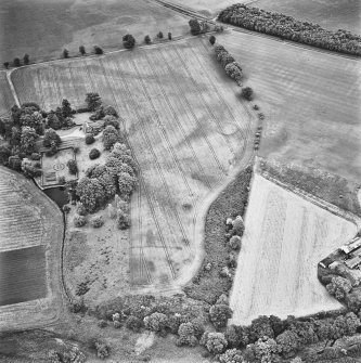 Inverdunning House and Wellhill, oblique aerial view, taken from the WNW, centred on the cropmarks of enclosures, ring-ditches, pit-circles, rig, cropmarks and pits. Inverdunning House and walled garden are visible in the centre left half of the photograph.