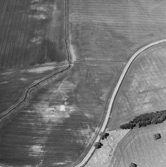 Oblique aerial view centred on the cropmarks of the pits, rig and enclosure, taken from the SE.