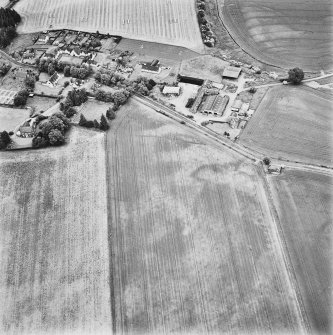 Forteviot, oblique aerial view, taken from the SSE, centred on cropmarks including those of an enclosure, a barrow cemetery and pit-alignments. Forteviot village is visible in the top half of the photograph.