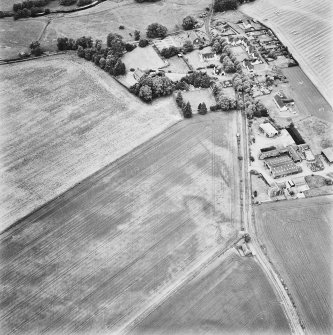 Forteviot, oblique aerial view, taken from the ESE, centred on cropmarks including those of an enclosure, a barrow cemetery and pit-alignments. Forteviot village is visible in the top right-hand corner of the photograph.