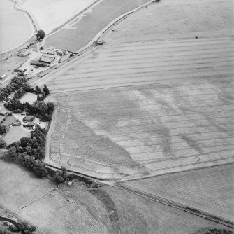 Oblique aerial view centred on the cropmarks of the enclosures with the manse adjacent, taken from the WSW.
