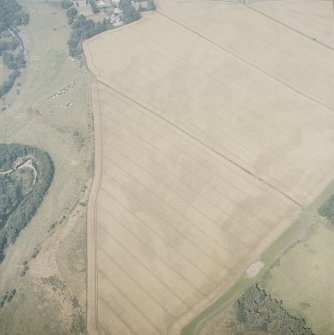 Oblique aerial view in hazy conditions centred on the cropmarks of the enclosure, with the cropmarks of the henges, possible henge, pit-enclosure, barrows, square barrows, cemetery, pit-alignments, enclosures, ring-ditches and other cropmarks adjacent, taken from the SSW.