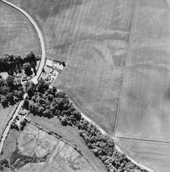 Oblique aerial view centred on the house, gate-lodge and cottage with the cropmarks of rig adjacent, taken from the NE.