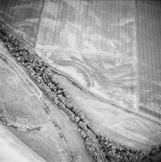 Oblique aerial view centred on the geological cropmarks with rig adjacent, taken from the NE.