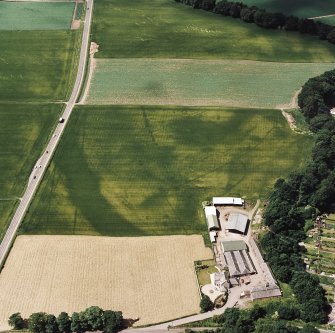 Oblique aerial view centred on the cropmarks of an enclosure, pit-circle, Roman Road, linear cropmarks, pits and pit-alignment, taken from the ENE.
