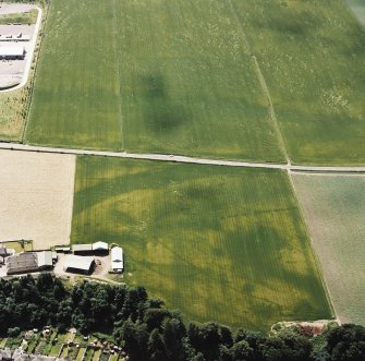 Oblique aerial view centred on the cropmarks of an enclosure, pit-circle, Roman Road, linear cropmarks, pits and pit-alignment with linear cropmarks adjacent, taken from the N.