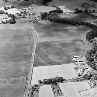 Oblique aerial view centred on the cropmarks of an enclosure, pit-circle, Roman Road, linear cropmarks, pits and pit-alignment with linear cropmarks and castle adjacent, taken from the E.
