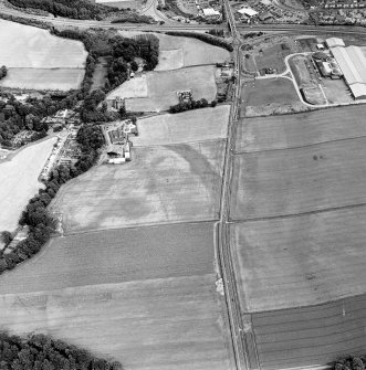 Oblique aerial view of Huntingtower and Huntingtower Mains centred on the cropmarks of a Roman road, enclosure, pit-circle, pits and various linear cropmarks and miscellaneous cropmarks, taken from the WNW.