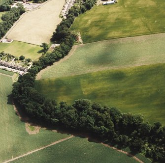 Oblique aerial view centred on the cropmarks of an enclosure and rig with enclosure, pit-circle, Roman Road, linear cropmarks and pits adjacent, taken from the W.