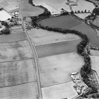 Oblique aerial view of Huntingtower centred on the cropmarks of a Roman road and various linear and miscellaneous cropmarks, taken from the ESE.