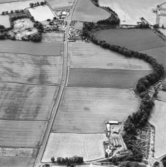 Oblique aerial view of Huntingtower centred on the cropmarks of a Roman road and various linear and miscellaneous cropmarks, taken from the E.