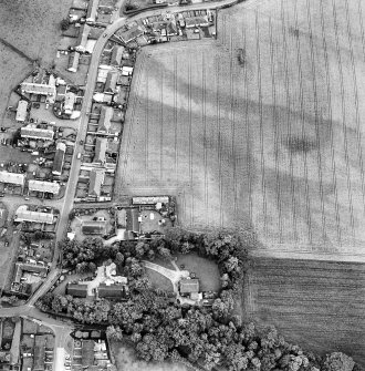 Oblique aerial view of Bankfoot centred on pits visible as cropmarks, with Auchtergaven Parish Church Manse adjacent, taken from the NNE.