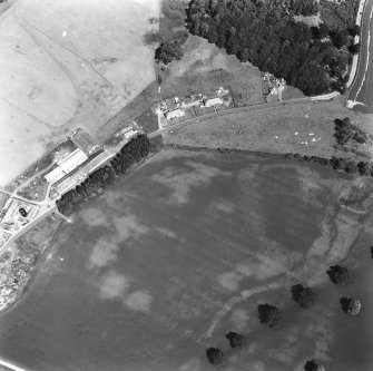 Ballathie, oblique aerial view, taken from the SSW, showing the cropmarks of a group of pits in the centre of the photograph, and an unenclosed settlement in the bottom right-hand corner.  A dismantled railway is visible as a cropmark in the bottom right-hand corner.