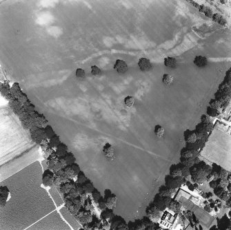 Ballathie, oblique aerial view, taken from the S, showing the cropmarks of an unenclosed settlement in the centre of the photograph, and pits in the top right-hand corner.  A dismantled railway is visible as a cropmark across the top half.