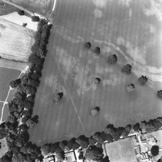 Ballathie, oblique aerial view, taken from the SSE, showing the cropmarks of an unenclosed settlement in the centre of the photograph, and pits in the top right-hand corner.  A dismantled railway is visible as a cropmark across the top right-hand corner area.