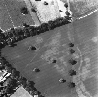 Ballathie, oblique aerial view, taken from the E, showing the cropmarks of an unenclosed settlement in the centre, and pits in the bottom right-hand corner.  A dismantled railway is visible as a cropmark along the right half of the photograph.