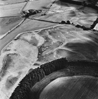 Wester Drumatherty, oblique aerial view, taken from the NW, centred on the cropmarks of a Roman road and quarry pits, a linear cropmark and an unenclosed settlement.