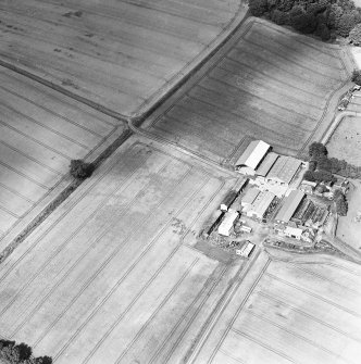 Oblique aerial view centred on the farmhouse and farmsteading, taken from the SSW.