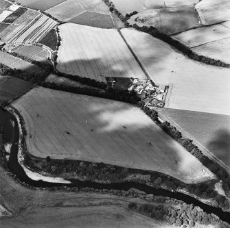 Oblique aerial view centred on the site of a pit-defined cursus and enclosure, taken from the SE.
