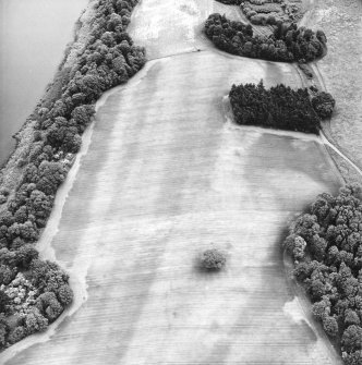 Mugdrum, oblique aerial view, taken from the W, centred on an area defined as a cropmark complex. The cropmarks of a possible enclosure are visible in the top right-hand corner of the photograph.