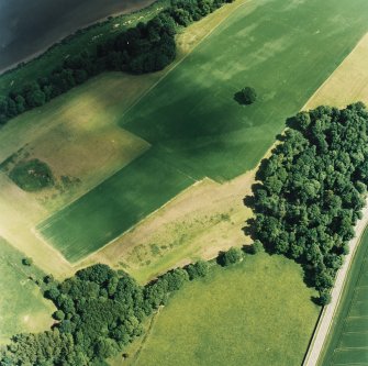 Oblique aerial view centred on the cropmarks of the enclosures, pits and rig, taken from the SW.