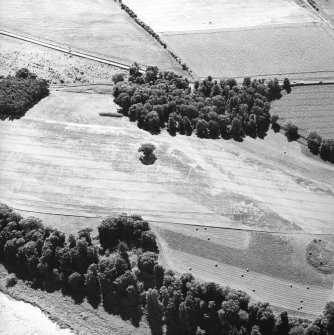 Oblique aerial view centred on the of the cropmarks of the enclosures, pits and rig, taken from the NNW.