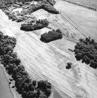 Oblique aerial view centred on the of the cropmarks of the enclosures, pits and rig, taken from the W.