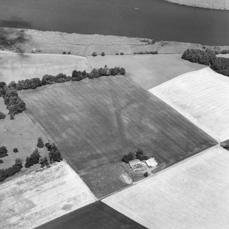 Oblique aerial view centred on the cropmarks of the E and S ditches of the Roman Fortress, with the farmsteading adjacent, taken from the S.    
