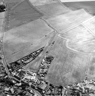 Oblique aerial view centred on the cropmarks of the S end of the Roman Temporary Camp with possible unenclosed settlements and town adjacent, taken from the WNW.