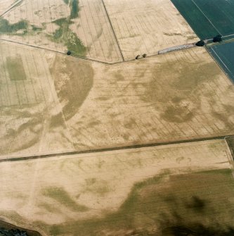 Oblique aerial view centred on the cropmarks of the pit-defined cursus, pits and rig, with pits, rig, ring-ditch and possible quarry adjacent, taken from the S.