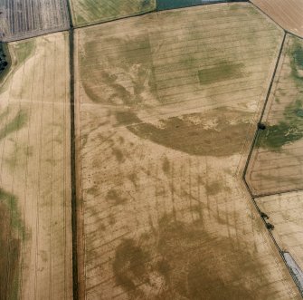Oblique aerial view centred on the cropmarks of the pit-defined cursus, pits and rig, with pits, rig, ring-ditch and possible quarry adjacent, taken from the E.
