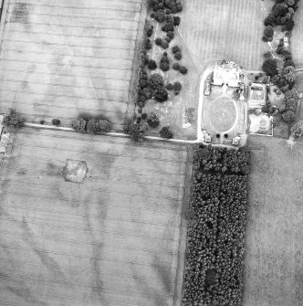 Oblique aerial view centred on the cropmarks of the ring-ditch with country house adjacent, taken from the SW.