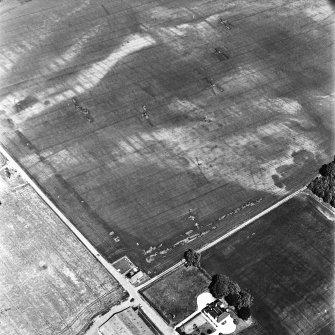 Hill of Errol, oblique aerial view, taken from the SSW, centred on the cropmarks of two unenclosed settlements, rig, ring-ditch, souterrains, various cropmarks and a pit-alignment. Hill of Errol farmhouse is visible in the bottom right-hand corner of the photograph.