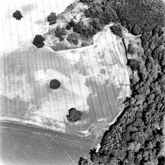 Rossie, oblique aerial view, taken from the S, centred on a series of indeterminate cropmarks and the marks of an enclosure and a trackway. Rossie Church is visible in the top centre of the photograph.