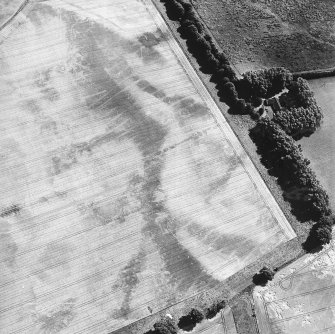 Oblique aerial view centred on the cropmarks of the round barrows, square barrows, enclosure, roundhouse, pits, field boundary, pit-alignment and rig, taken from the WSW.