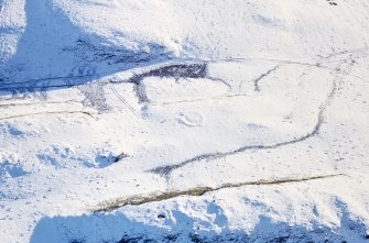 Oblique aerial view of Castle Hill centred on the remains of a ring-ditch house with a fort and mound adjacent, taken from the NW.