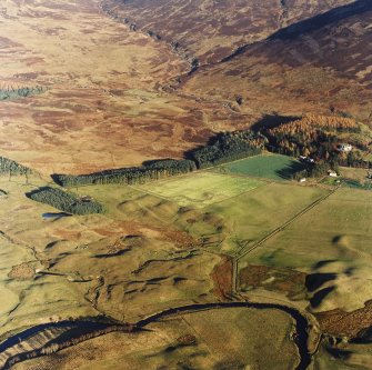 Oblique aerial view centred on the remains of farmsteads, buildings, small carins and rig with hut-circles, small cairns, banks, huts, rig and hunting lodge adjacent, taken from the WSW.
