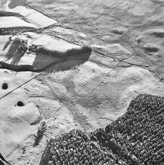 Oblique aerial view centred on the remains of three farmsteads with ring ditch house, possible hut circle, buildings, farmstead and farmsteading adjacent, taken from the NNE.