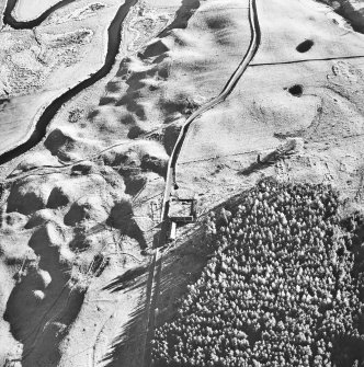 Oblique aerial view centred on the remains of a hut circle with three farmsteads and ring ditch house adjacent, taken from the NNW.