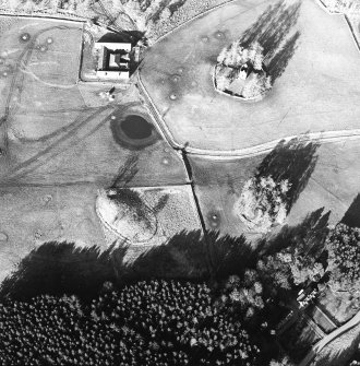 Oblique aerial view centred on the ruins of the tower-house with farmsteading adjacent, taken from the SSW.