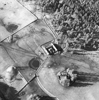 Oblique aerial view centred on the ruins of the tower-house with farmsteading adjacent, taken from the SE.