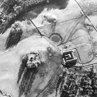 Oblique aerial view centred on the ruins of the tower-house with farmsteading adjacent, taken from the NE.