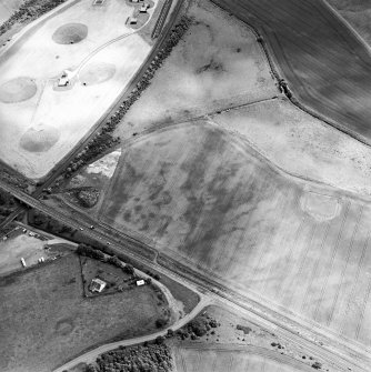 Oblique aerial view centred on the cropmarks of an unenclosed settlement and linear cropmarks, taken from the WNW.