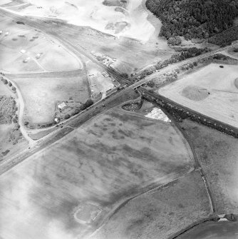 Oblique aerial view centred on the cropmarks of an unenclosed settlement and linear cropmarks, taken from the SSE.