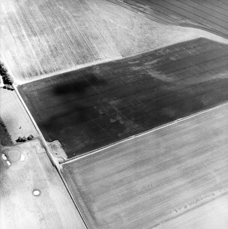Oblique aerial view centred on the cropmarks of the ring-ditches, enclosures and rig with the war memorial adjacent, taken from the W.