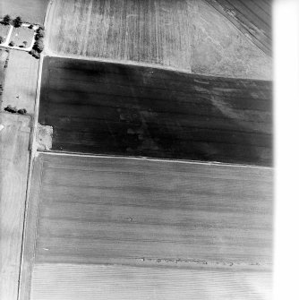 Oblique aerial view centred on the cropmarks of the ring-ditches, enclosures and rig with the war memorial adjacent, taken from the WSW.
